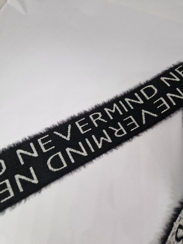 Стрічка мʼяка шерстяна чорно-біла з написом nevermind 4 см